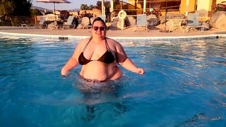 BBW bouncing in the pool in a string bikini